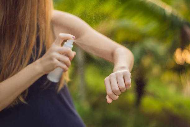 Foto de uma mulher aplicando repelente contra mosquitos no braço